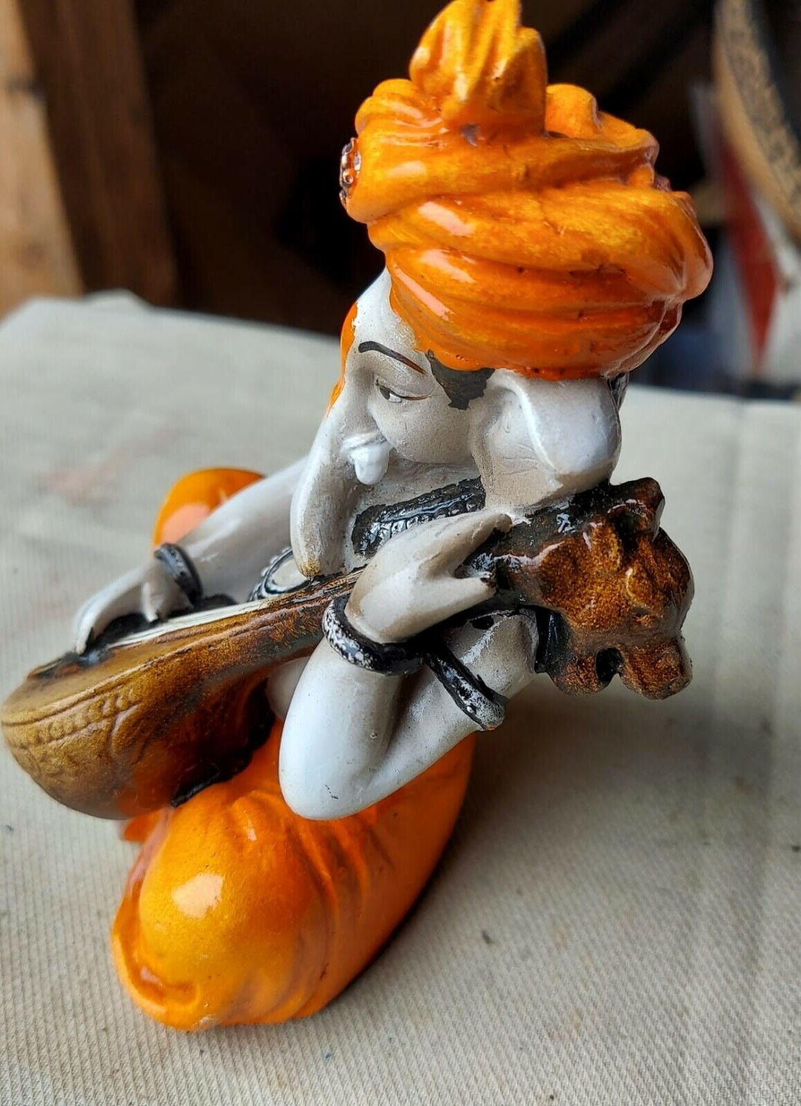 Karigaari India Karigaari Polyresine Ganesha Playing Instrument Orange Figurine