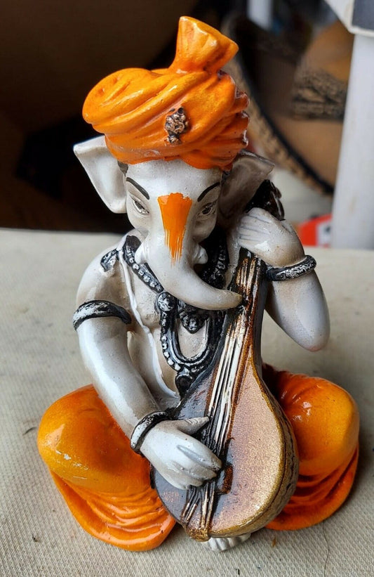 Karigaari India Karigaari Polyresine Ganesha Playing Instrument Orange Figurine